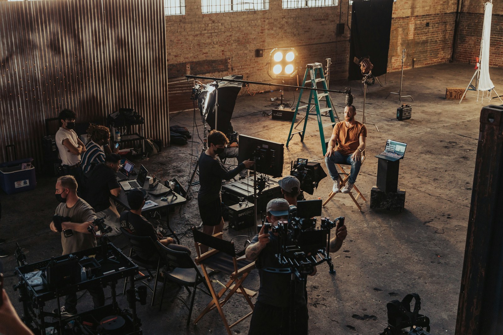 Film crew on a corporate video production set with lighting, camera rig and monitors