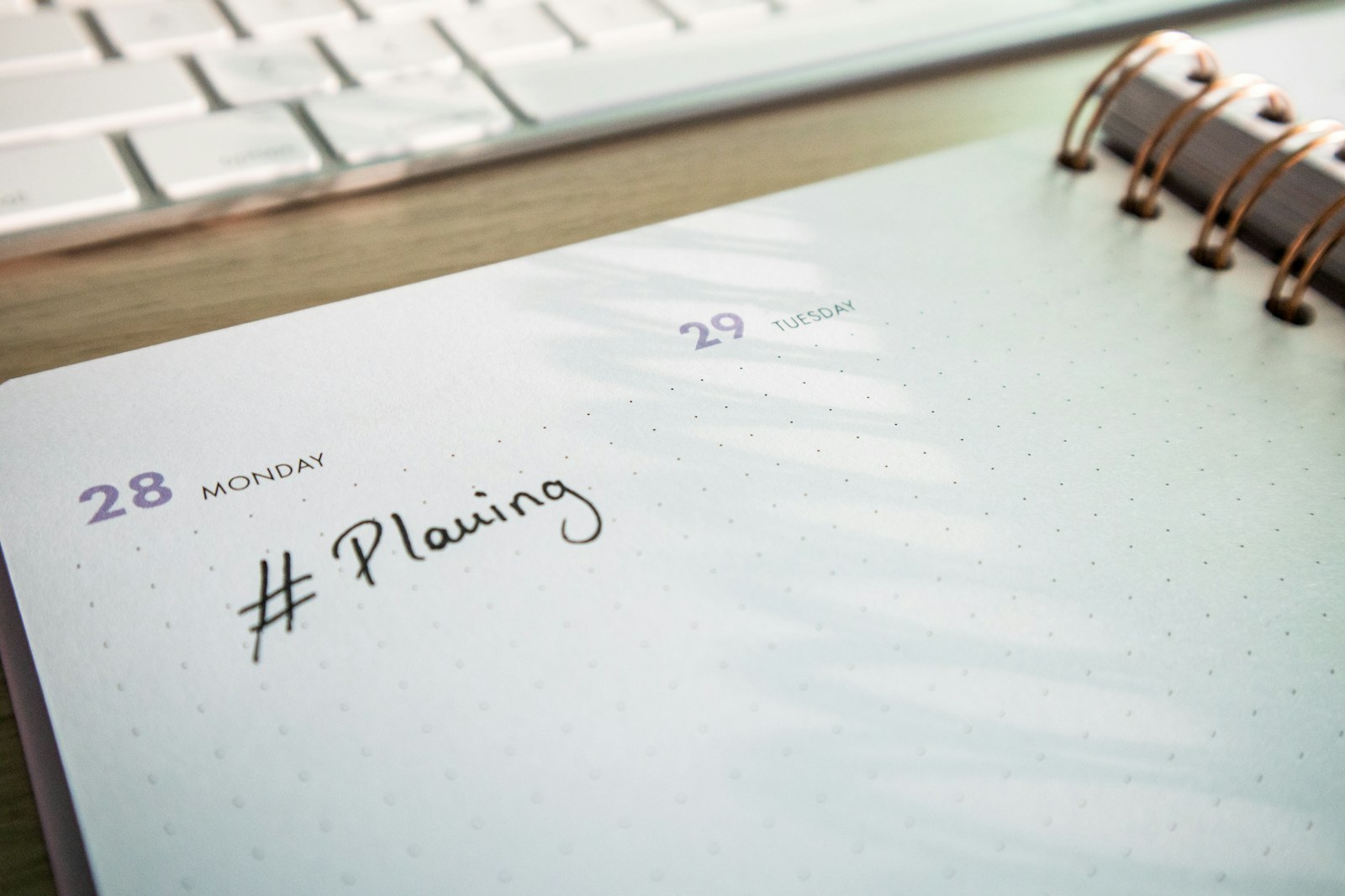 Content calendar planner and keyboard on a desk, social media management and content creation for brands